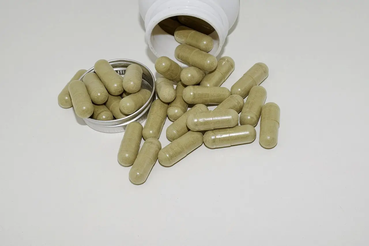 Green supplement capsules spilling from a jar
